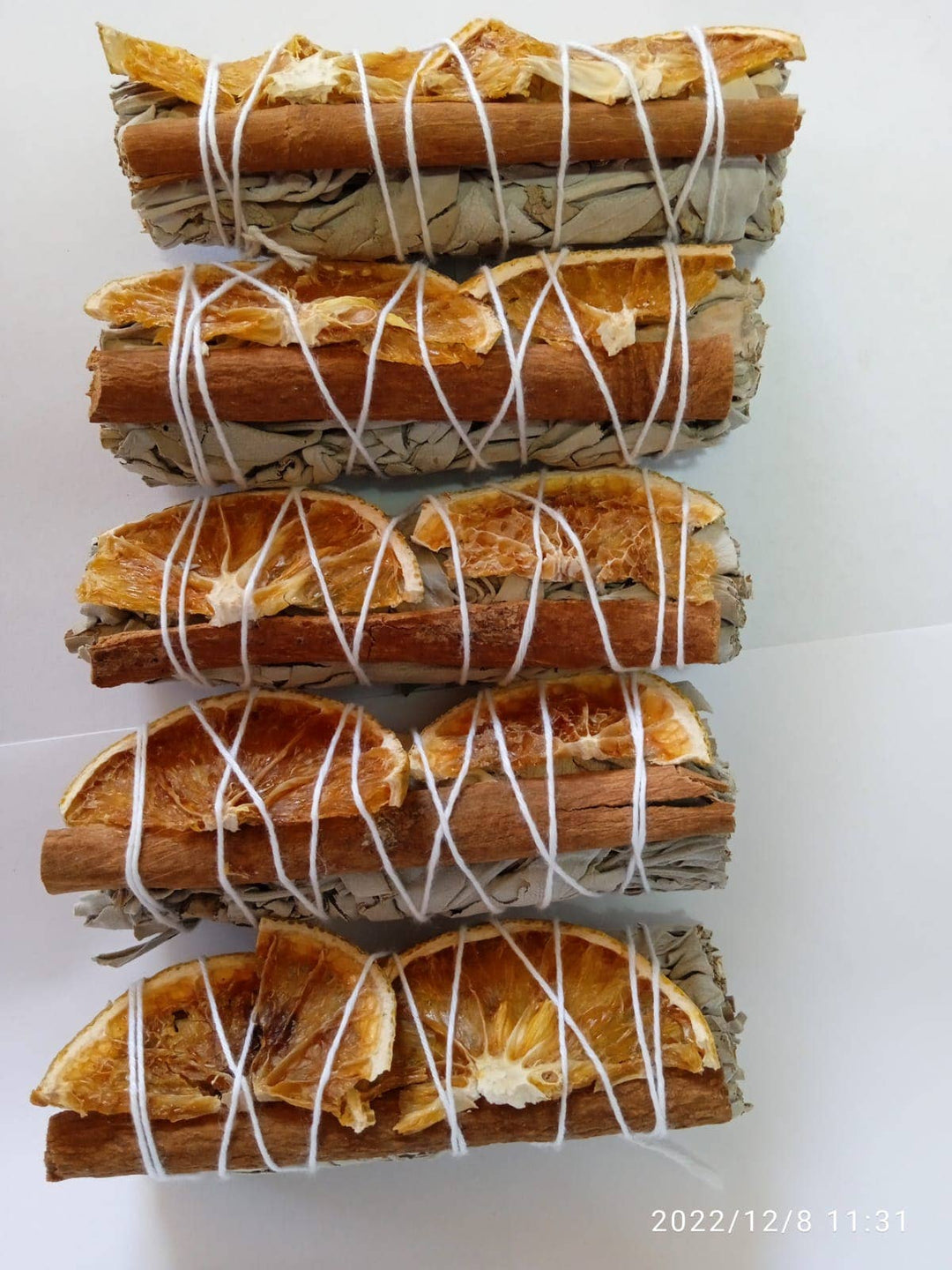 Handcrafted orange slices and cinnamon with white sage bundle for cleansing rituals