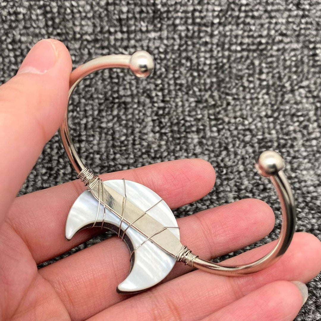 Moon Shape Natural Abalone Shell Cuff Bangle resting in warm coastal light