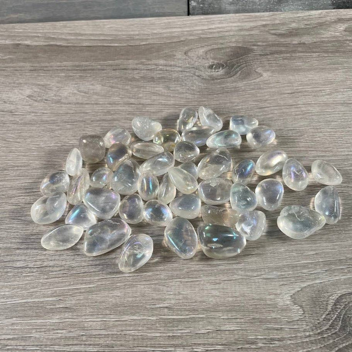 Angel Aura Quartz Tumbled Stones bulk bag glowing with rainbow iridescent shimmer