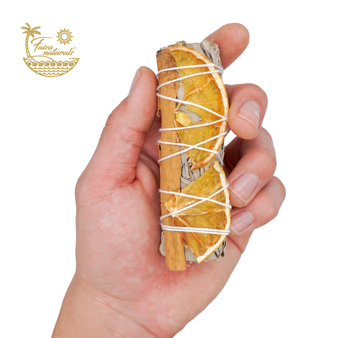 Handcrafted orange slices and cinnamon with white sage bundle for energy clearing rituals