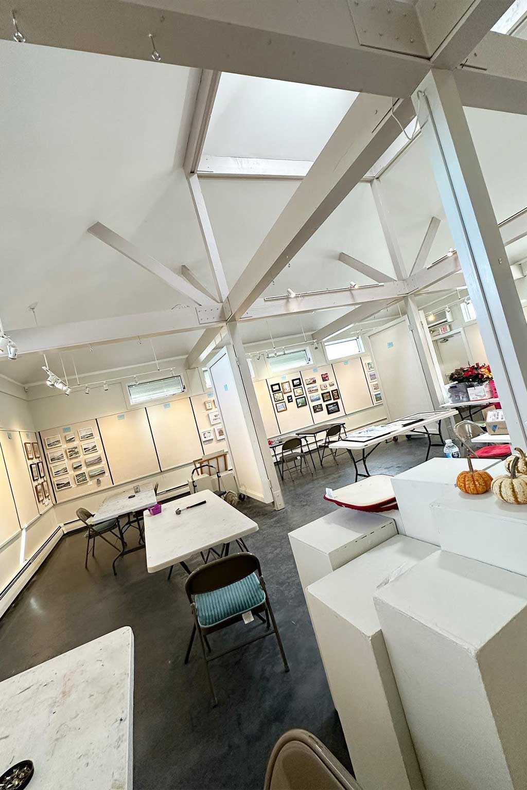 Modern office space with white walls, desks, and chairs.