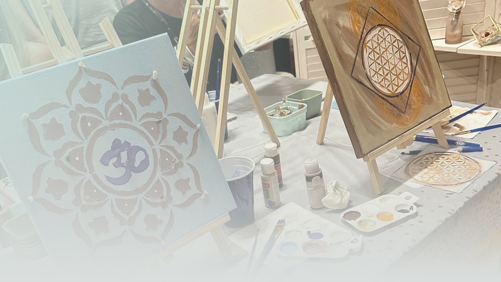 Art supplies including stencils and paint on a table with a blurred background